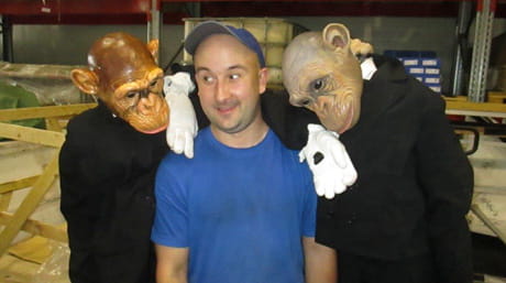 DSV warehouse employee surrounded by theatre characters - in monkey suits