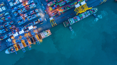 Porto com containers e dois navios no mar