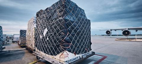 Packed goods on airport tarmac ready to be loaded