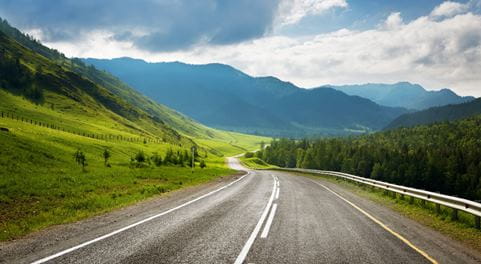 Road in between green hills