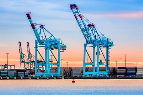 Two cranes at a sea port in evening light