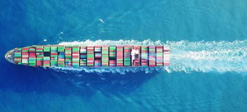 Containerskib sejler set ovenfra fyldt med containere