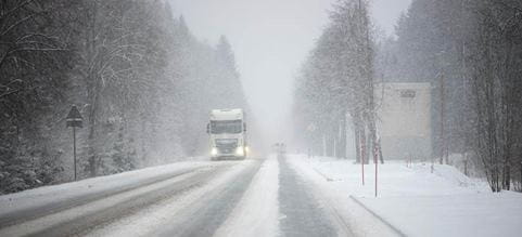 Lastbil kører i snevejr