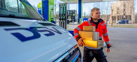 DSV:n asuun pukeutunut kuljettaja toimittaa paketteja noutopisteelle.
