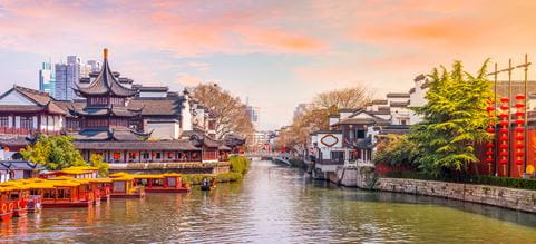 Ciudad y paisaje chino con un atardecer hermoso, los edicios emblematicos y los modernos al fondo.