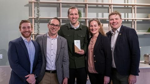 Three DSV Employees with a sustainability award and customers