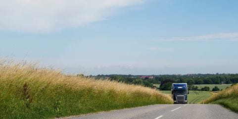 Truck driving by wheat fields