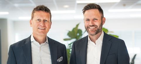 two men in suits smiling