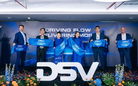 Business leaders posing with banners at an event, reflecting partnership and shared success.