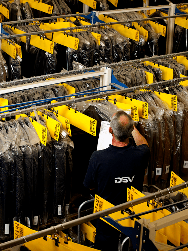 man handling clothes in a warehouse