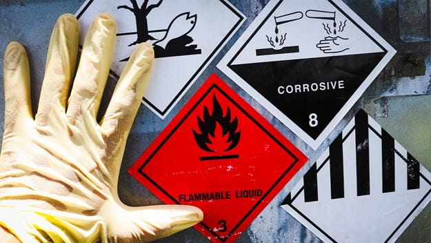 Hazard warning labels on cargo container: corrosive, flammable liquid.