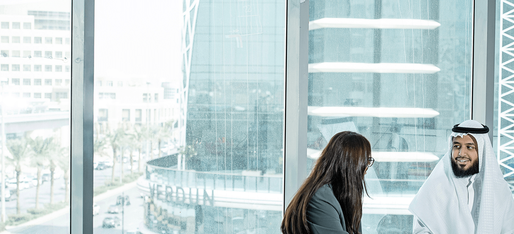 sitting colleagues talking in front of a glas window