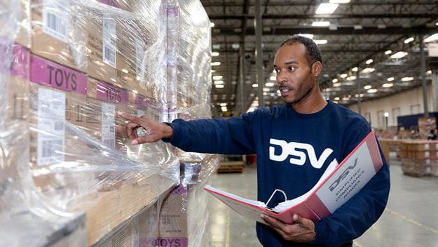 DSV employee recording cargo in Kuwait warehouse