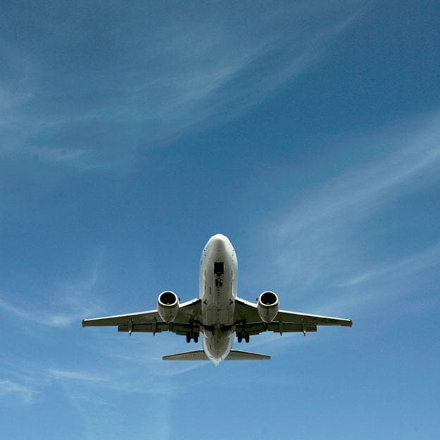 Fly der flyver på en blå himmel