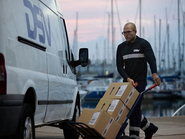 DSV medarbejder der kører med pakker på sækkevogn
