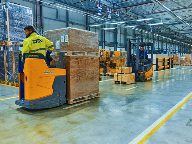 To trucks der kører med varer på et DSV lager