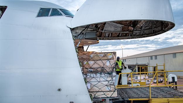 Valkoiseen lentokoneeseen lastataan lähetyksiä.