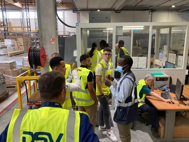 groupe de personne dans un entrepôt avec gilets jaunes DSV