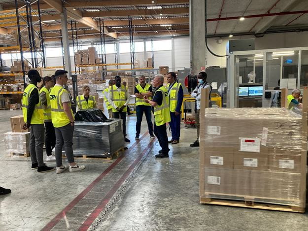 groupe de personne dans un entrepôt avec gilets jaunes DSV