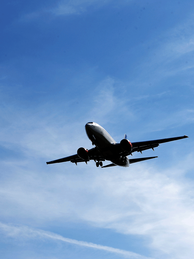 Ground view of a flying airplane