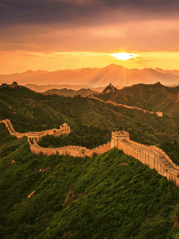 aerial view of the great wall of china with a sunset or sunrise in the background