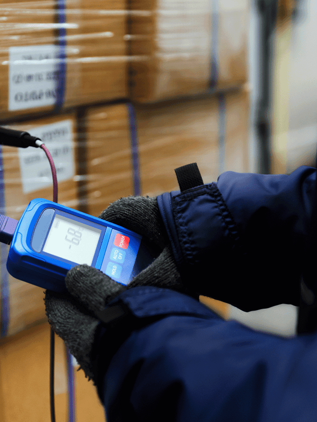 man checking temperature which is showing over minus 60 degrees on the device