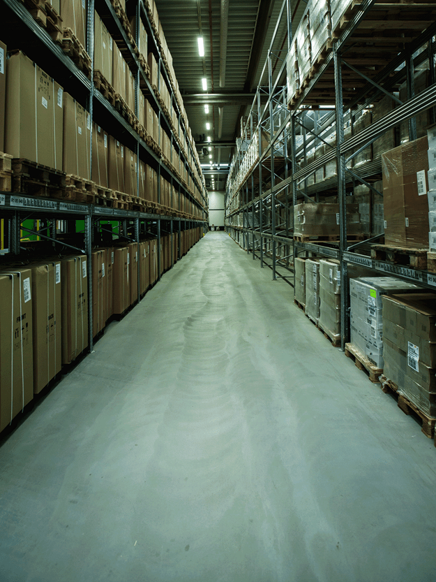 alley way inside of a warehouse with stacked items on both sides