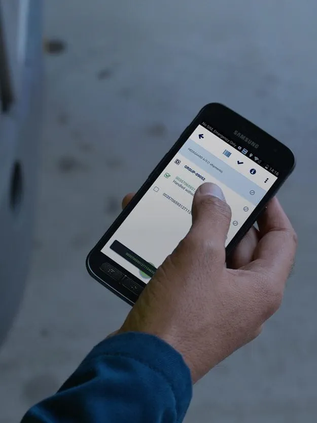 A hand holds a smartphone displaying a logistics or tracking application.