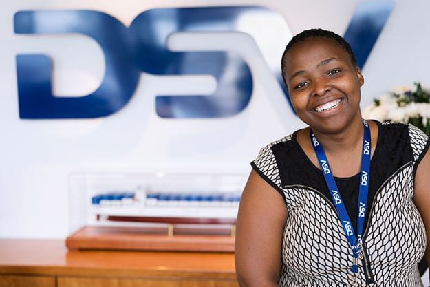 Female employee in front of the DSV logo
