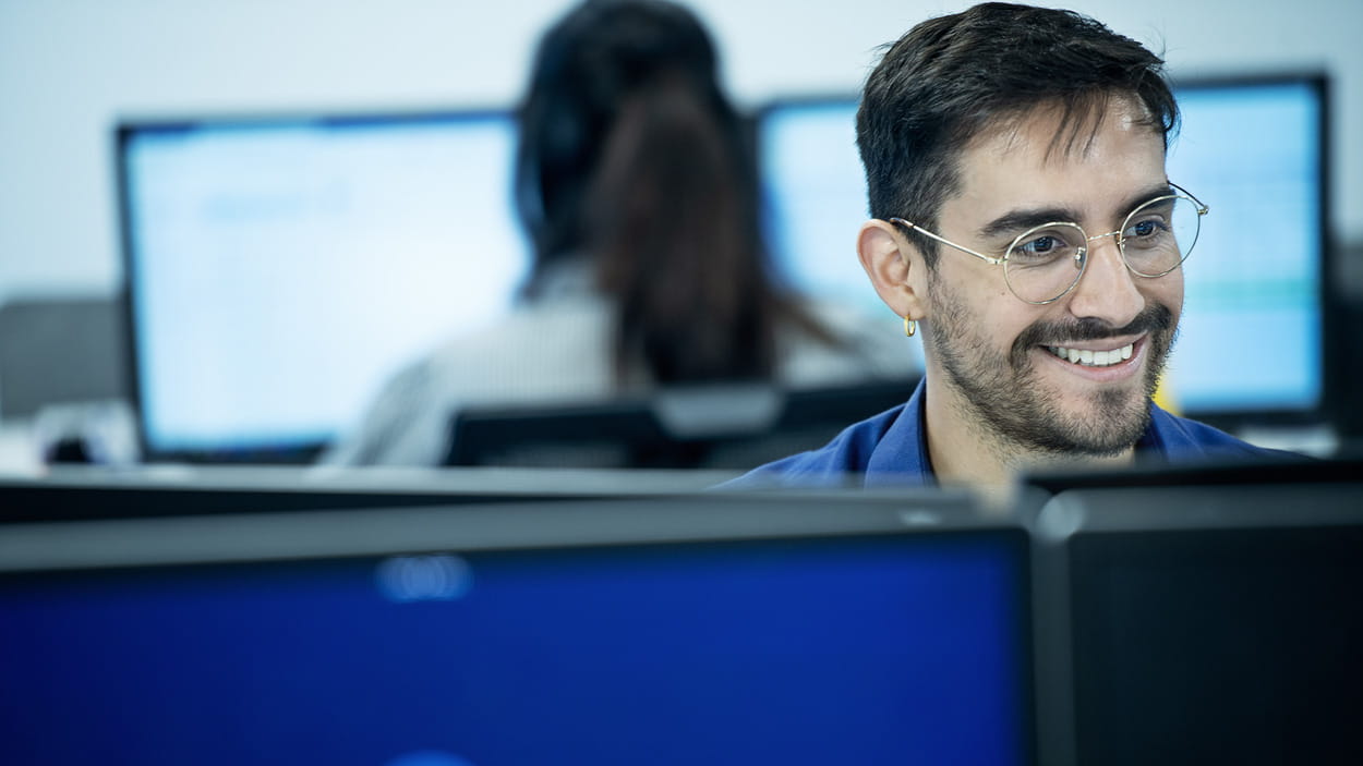  Une personne portant un t-shirt DSV travaille à un ordinateur.