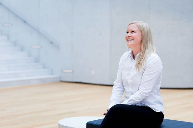 Female DSV employee sitting in the atrium of the DSV headquarter in Hedehusene