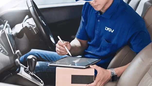 delivery man checking parcel on his tablet