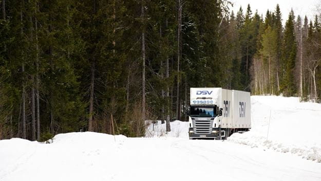 White DSV truck driving in snow in a forest