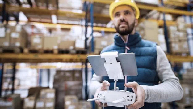 DSV staff utilizing drones in warehouse operations for inventory management.