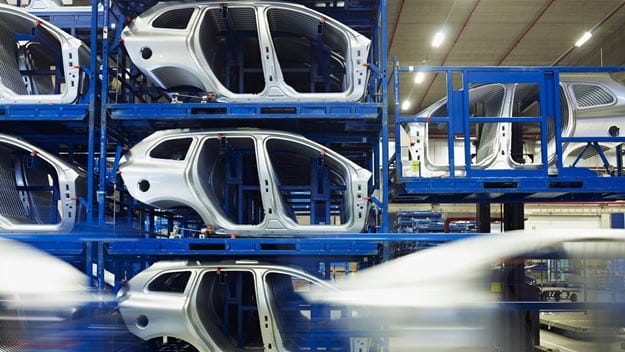 Car on assembly line with open trunk