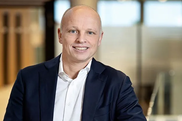 Jens Lund in the office in Hedehusene. Smiling to the camera.