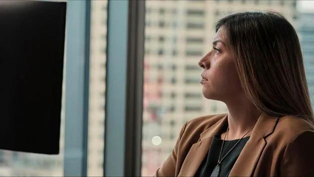 A woman is in front of the computer, peering through the window.
