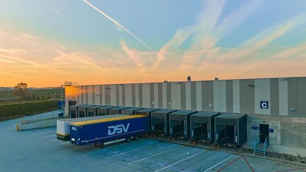 DSV truck at warehouse loading docks during sunset operations.