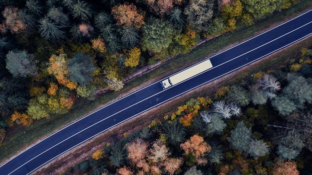 Truck on a road through a forest 