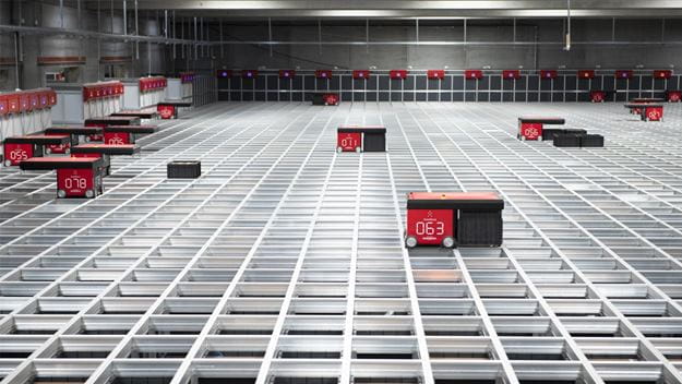 Avansert lager med automatiserte sorteringsroboter som opererer på et stort rutenett av metallskinner