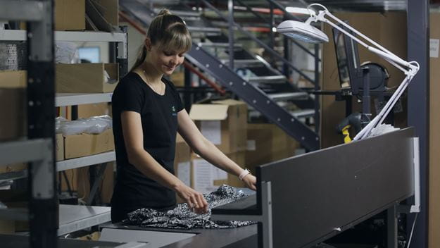 Vrouwelijke magazijnmedewerker die retouren classificeert