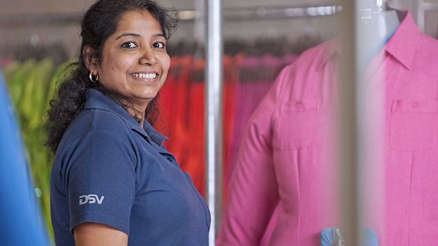 Vrouwelijke magazijnmedewerker die kleding behandelt