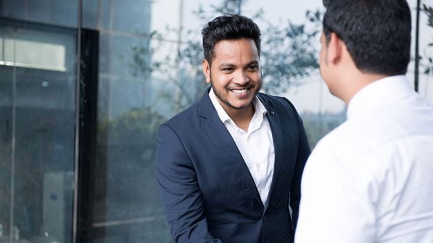 Business professionals shaking hands outside an office building during a meeting