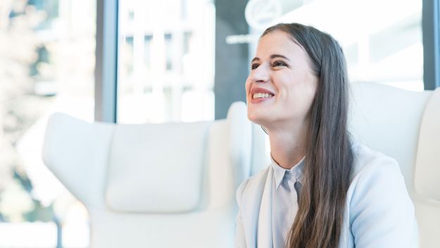 Smiling businesswoman sitting in a modern office environment during a conversation