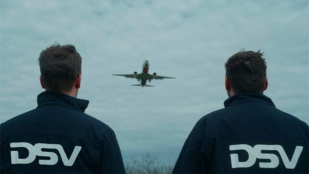 dsv transport en logistiek twee dsv medewerkers kijken naar vliegtuig