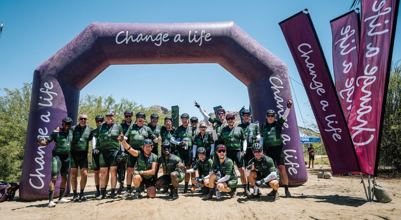 Change a life cycle tour riders posing for a photo together in Namibia