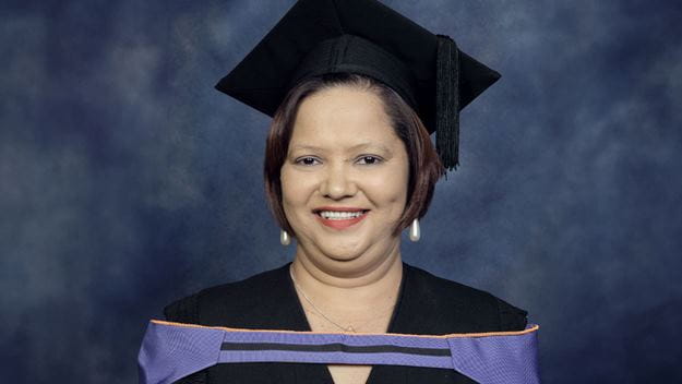 Priscilla Klein in graduate clothing smiling happily