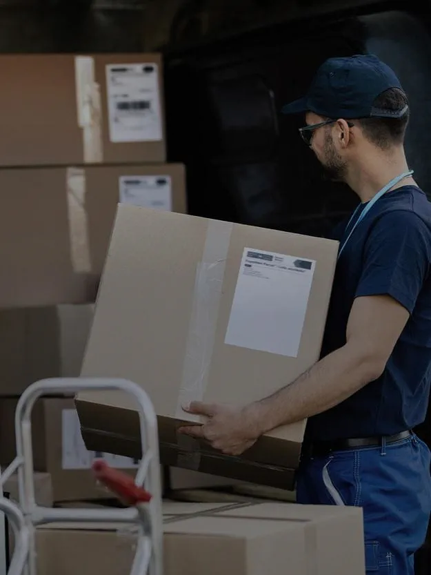  courier unloads boxes from a van, representing professional and timely shipment of goods.
