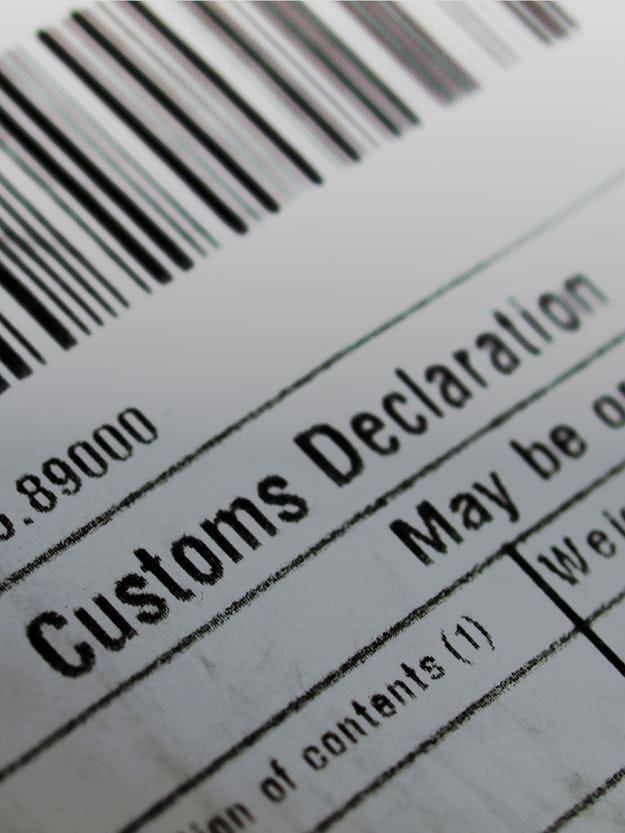 A close-up shows a portion of a Customs Declaration form with a barcode at the top, suggesting documentation for international shipping or trade.