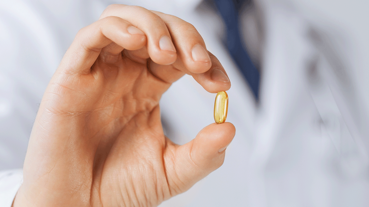 person holding a pill in the hand